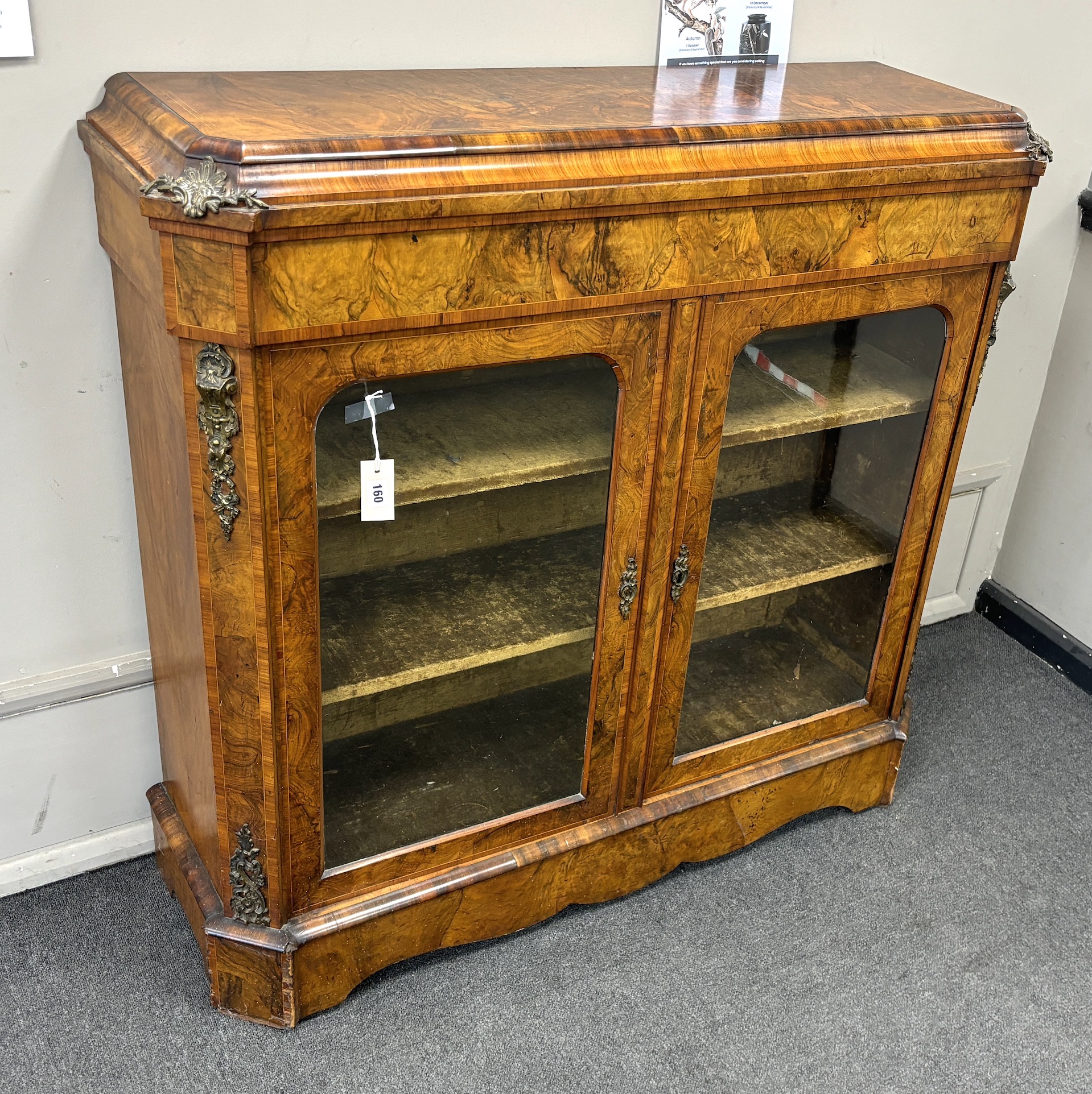 A mid Victorian tulip banded and gilt metal mounted figured walnut two door glazed side cabinet, width 114cm, depth 35cm, height 109cm.